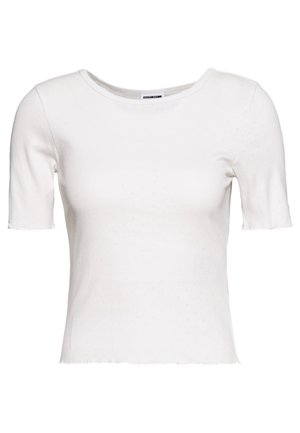 Haut blanc à manches courtes en tissu léger, avec un col rond et un ourlet légèrement raccourci orné d'un motif texturé subtil.