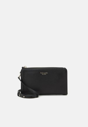 Zwarte leren rechthoekige polstasje met gouden ritssluiting en verstelbare band, merknaam "kate spade new york" in gouden letters.