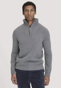 Grauer Pullover mit hohem Kragen, geripptem Textur und Reißverschluss. Mit langen Ärmeln und einem taillierten, gerippten Saum.
