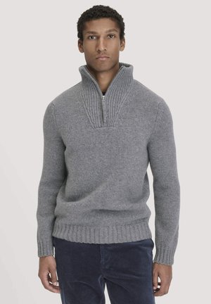 Grijze sweater met hoge kraag, geribbelde textuur en ritssluiting. Heeft lange mouwen en een aansluitende geribbelde zoom.