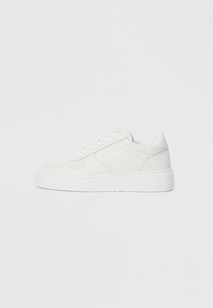 Witte sneakers met een glad bovenwerk, geperforeerde details en een dikke witte zool. Beschikt over eenvoudige veters en een ronde neusdesign.
