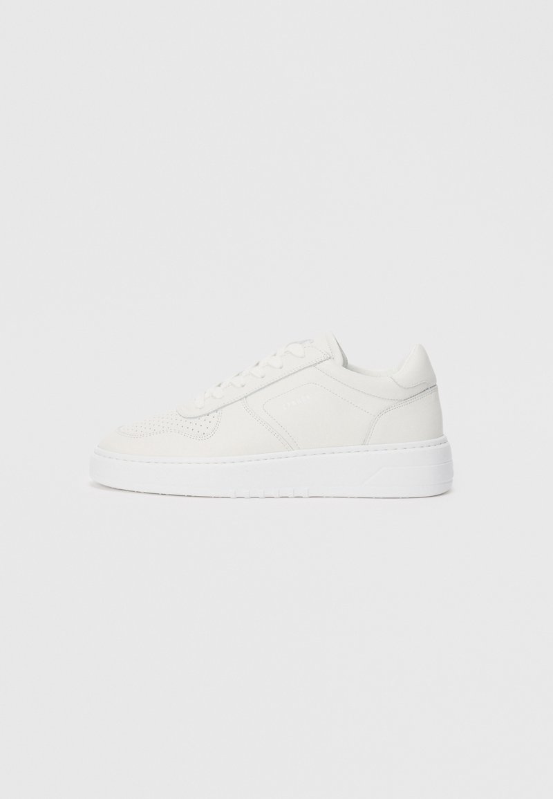 White sneakers with a smooth upper, perforated detailing, and a thick white sole. Features simple lacing and a rounded toe design.