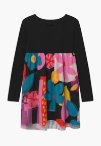 Czarna sukienka z długim rękawem i żywym, wielokolorowym dołem w kwiaty, z dużymi, wyrazistymi kwiatami w odcieniach różu, niebieskiego, żółtego i czerwonego.