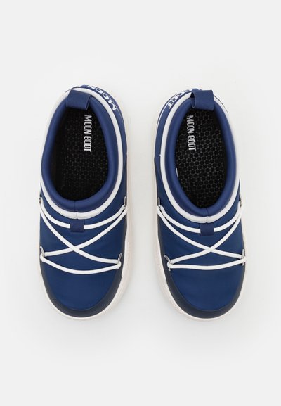 Pantofi slip-on bleumarin cu șireturi elastice albe, fabricați dintr-un material texturat. Au un vârf rotund și o talpă solidă din cauciuc.