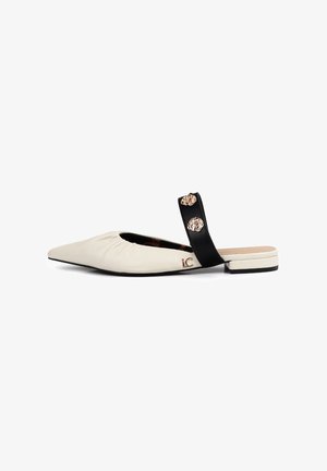 Pointed-toe flats with a creamy white leather upper, black strap featuring decorative gold accents, and a low block heel.