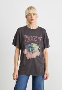 Voľný tmavosivý tričko s ružovým logom "ROXY", grafiku vĺn a kvetinové akcenty. Krátke rukávy s uvoľneným výstrihom.