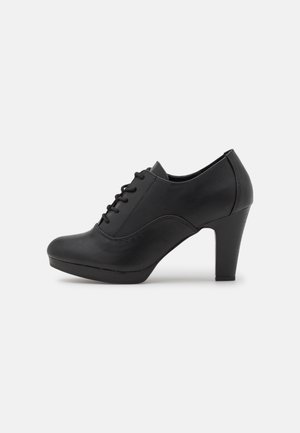 Czarne wysokie buty na obcasie z zaokrąglonym noskiem, sznurowane, wykonane ze gładkiej skóry, z obcasem o wysokości 7,5 cm i minimalną ilością przeszyć.