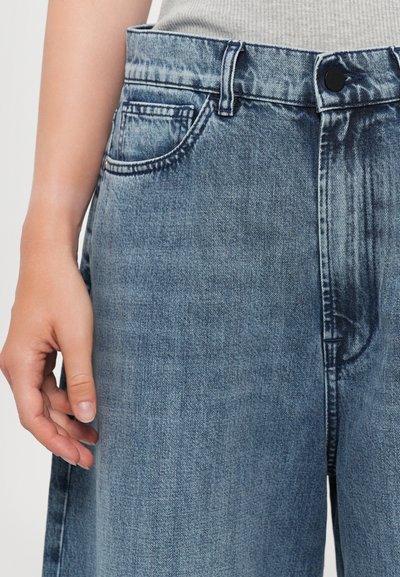 Jeans in denim azzurro chiaro con una vestibilità regolare, design a cinque tasche, chiusura frontale con bottone e leggera scoloritura in corrispondenza della vita e delle cosce.