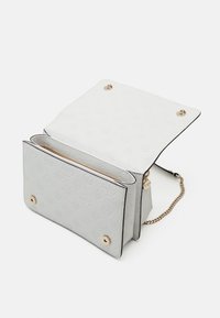 Hvid prægning håndtaske med guldlåse, to rum og en kædesti. Har en glat overflade og kontrasterende sorte kanter.