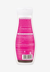 Butelka na balsam do ciała o zakrzywionym kształcie, wykonana z białego plastiku, z różowym napisem i pokrywką na klapkę; zawiera 200 ml nawilżającego kremu.