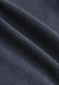 Ciemnogranatowa tkanina o gładkiej fakturze, z delikatnym ukośnym prążkowaniem, podkreślająca miękkie i trwałe sploty.