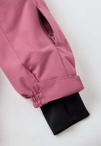 Roze waterdichte jasmanchet met een elastische tailleband, voorzien van een ritszak aan de zijkant en een zwarte rekbare stofvoering.