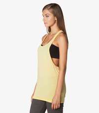 Gul ærmeløs tanktop laget av lett stoff, med løs passform, senkede armhull og buet nederkant. Brukt over en svart topp.