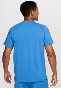 Maglietta atletica azzurra a maniche corte con una texture liscia e leggera. Caratterizzata da un colletto a girocollo e cuciture piatte per maggiore comfort.