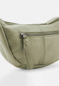 Borsa ovale verde in pelle con superficie texturizzata, dotata di chiusura con zip e un accento a frangia sul cursore della zip.