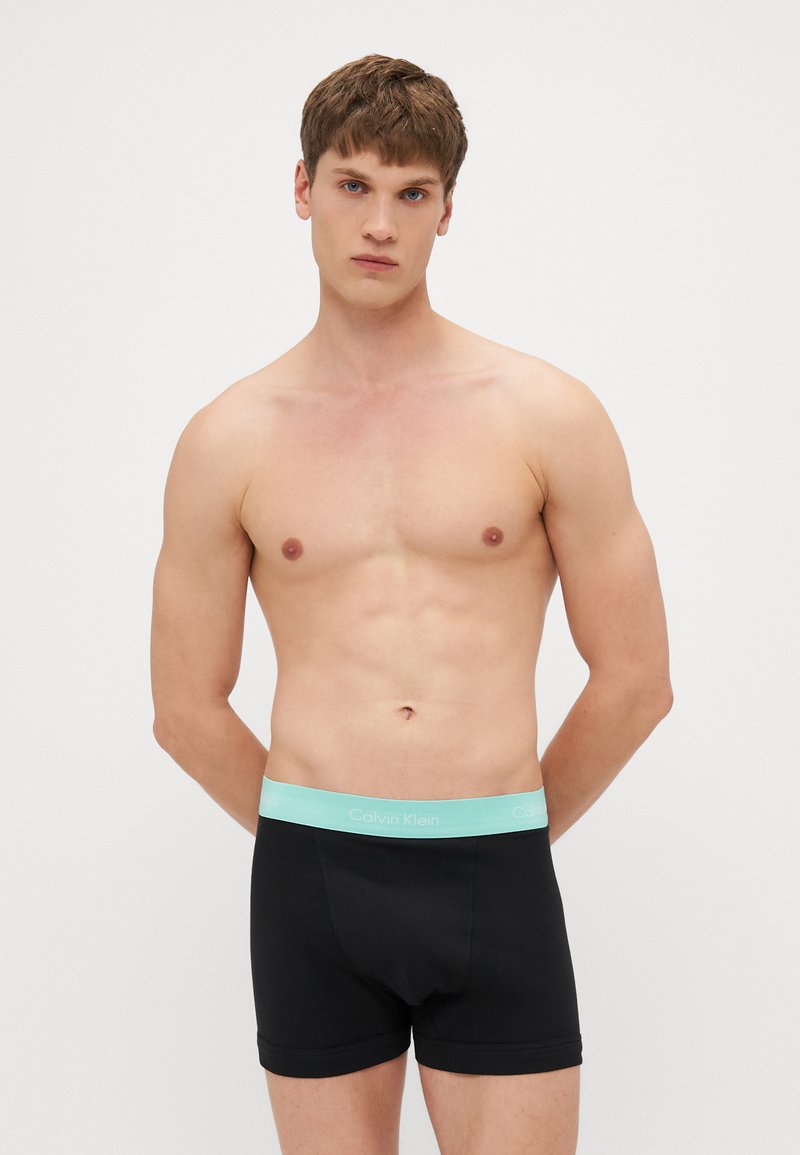Schwarze Baumwoll-Boxershorts mit einem hellblauen Calvin Klein-Logo-Bund. Kurz geschnitten mit einer glatten Textur und passgenauem Design.