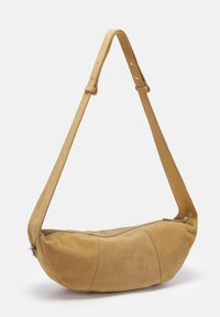 Suede shoulder bag in light brown, rounded shape with a zipper closure and an adjustable flat strap. Smooth texture with visible stitching details.
