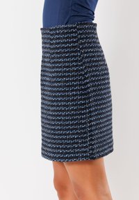 Gewobener Tweed-Rock in Dunkelblau und Hellblau mit strukturiertem Muster, hoher Taille und geradem Schnitt. Keine sichtbaren Beschläge oder Akzente.