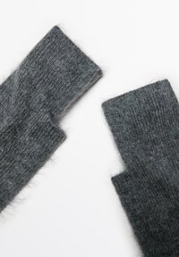 I guanti senza dita grigi lavorati a maglia presentano un tessuto morbido e testurizzato con un aspetto leggermente peloso, tagliati all'altezza del polso per facilitare il movimento.