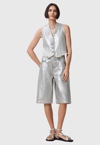 Silver metallic sleeveless vest with front buttons, paired with matching knee-length shorts. Smooth texture with a casual fit. Sandals complete the look.