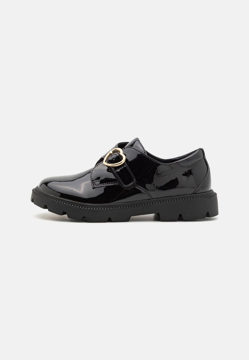 Chaussure en cuir verni noir avec semelle épaisse et boucle dorée en forme de cœur sur la bride latérale, vue de profil gauche.