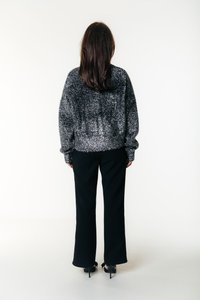 Mustad kõrge vöökohaga püksid, mida on kombineeritud halli pehme kootud kampsuniga. Kampsunil on lühendatud lõige ja pikad varrukad.