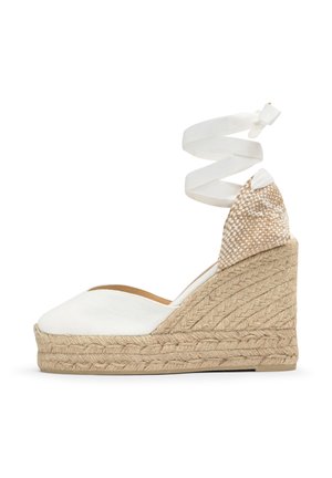 Biela espadrilová klinová sandála s tkanou juta platformou a pásikom na členok, zobrazujúca kockovanú tkaninu na päte.
