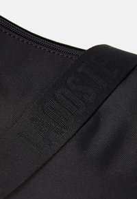 Black textured fabric bag with a zipper and a black strap embossed with the words "THE NORTH FACE."