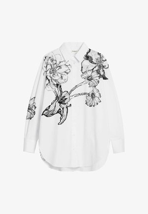 White button-up shirt featuring large black floral illustrations on the left side. Smooth fabric, long sleeves, and relaxed fit design.