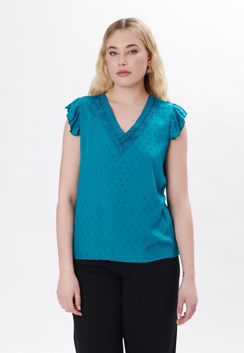 Blusa verde acqua con maniche corte a volant, scollatura a V e dettagli in pizzo ricamato. Il tessuto presenta un motivo a punti testurizzati.