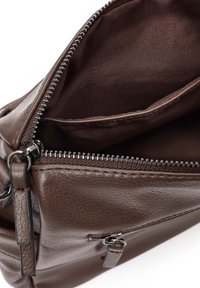 Bolso de mano de cuero marrón con superficie texturizada, con cierre de cremallera y bolsillos interiores. Los acentos incluyen herrajes en tono plata.