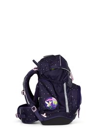 Purple backpack featuring white speckles, multiple pockets, reflective strips, and a round badge with a character design on the side.
