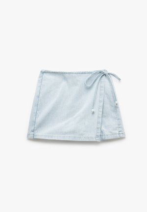 Light blue denim mini skirt with a wrap design, tied at the waist with a thin fabric belt, featuring a smooth texture and stitched hem.