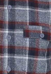 Geruite flanellen overhemd in grijs, marineblauw en bordeauxrood met knopen en een borstzak. Heeft een houndstooth patroon en subtiele textuur.