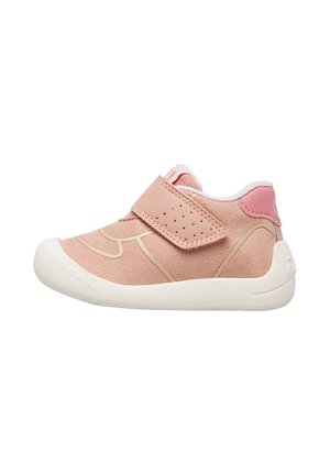 Scarpetta da bambino rosa chiaro con suola bianca, una cinghia in velcro perforata e colletto imbottito su sfondo bianco.