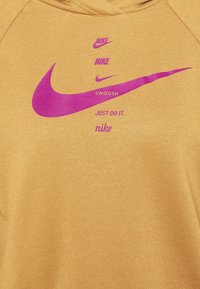Žlutá mikina s kapucí, na které jsou fialové loga Nike a text "SWOOSH". Materiál má hladkou strukturu a žebrované detaily.