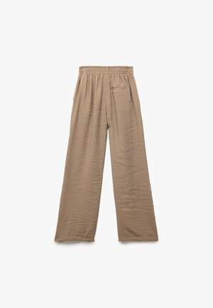 Vaaleanruskeat, leveät housut, joissa on teksturoidut materiaalit, joustava vyötärö ja yksi takatasku lisäämään käyttökelpoisuutta.