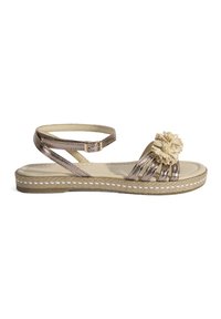 Metallisch bronze Sandale mit einem gewebten Riemendesign, ausgestattet mit einem dekorativen beigen Pom-Pom und einer strukturierten Espadrille-Sohle.