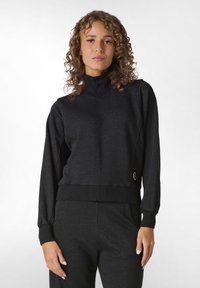 Pullover nero con collo alto e polsini a costine, caratterizzato da un design attillato e una texture sottile. Include un piccolo logo sull'orlo.