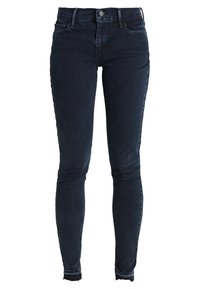Smaljeans i mörk denim med midjehög midja, klassisk femfickdesign och rå kant. Mjuk textur med lätt stretch.