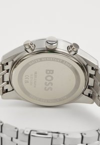 Orologio in acciaio inossidabile con cassa rotonda, finitura argento e tre pulsanti. Presenta le incisioni "BOSS" e "WATER RESISTANT 5 BAR" sul retro.