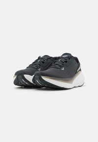 Black athletic shoes with a textured upper, sleek design, semi-translucent sole, and contrasting white midsole. Traction pattern on outsole.