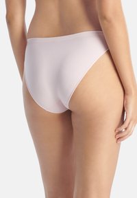 Mutandine di cotone rosa chiaro con una texture liscia, design a vita media e dettagli di cucitura minimi in vita e sulle gambe.