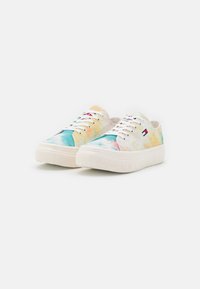 Lave sneakers med hvide snørebånd, tykke creme såler og multicolor tie-dye kanvas med et lille rødt, hvidt og blåt logo på siden.