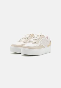 Beige platform sneakers with tonal stitching, leather and textured fabric, featuring gold accents and white rubber soles.