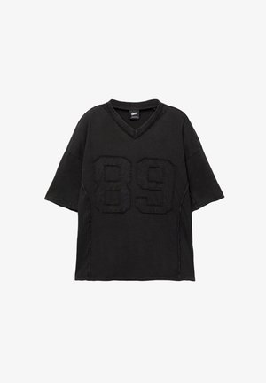 Čierne voľné tričko s krátkym rukávom a výstrihom do V, na prednej strane s veľkým vyšitým číslom "89" a textúrovaným povrchom.