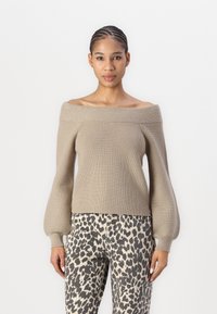 Khaki off-the-shoulder knit sweater with ribbed texture and balloon sleeves, paired with high-waisted animal print trousers, slim fit.