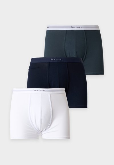Trois paires de boxers pour hommes en blanc, bleu marine et gris foncé, chacun avec une ceinture marquée Paul Smith.