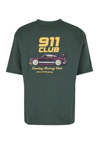Σκούρο πράσινο T-shirt με κίτρινο κείμενο «911 CLUB» και γραφικό με vintage μοβ αγωνιστικό αυτοκίνητο, μαζί με το κείμενο «Sunday Racing Club Motor Oil Company».