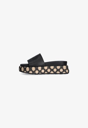 Black leather slide sandal with a wide strap and thick woven platform, featuring a textured tan and black pattern along the sole.